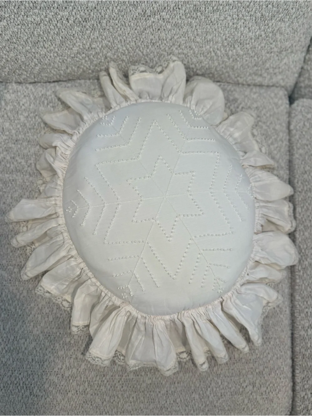 Handmade white candlewicking starburst pillow with ruffled lace trim.